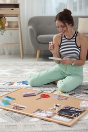 Woman creating vision board with different photos and other elements on floor indoors