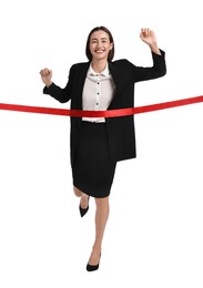 Young businesswoman in suit crossing red finish line on white background