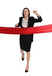 Young businesswoman in suit crossing red finish line on white background