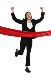 Young businesswoman in suit crossing red finish line on white background