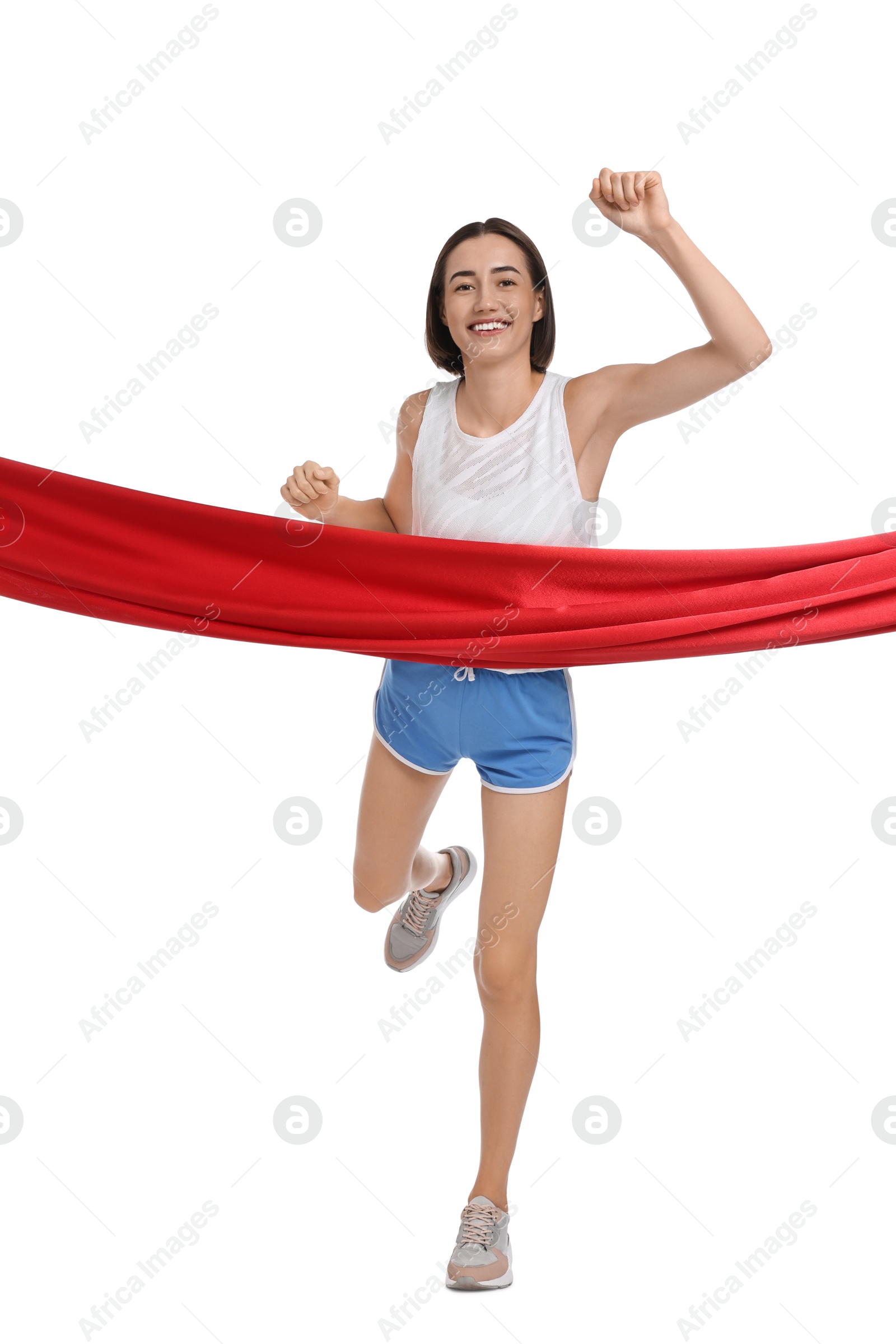 Photo of Beautiful woman in sportswear crossing red finish line on white background