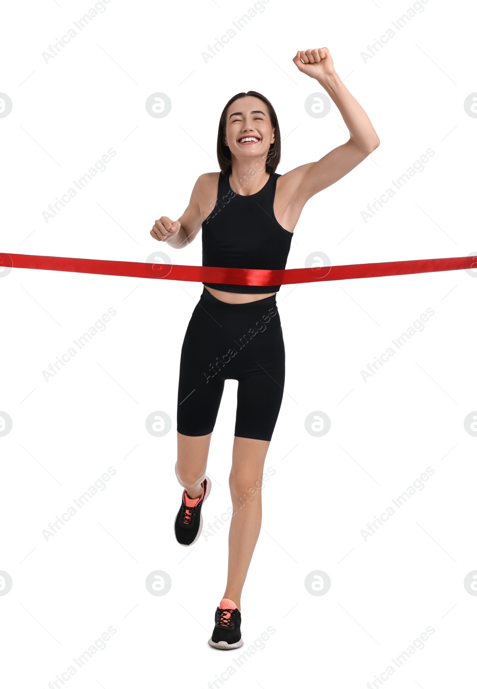 Photo of Beautiful woman in sportswear crossing red finish line on white background