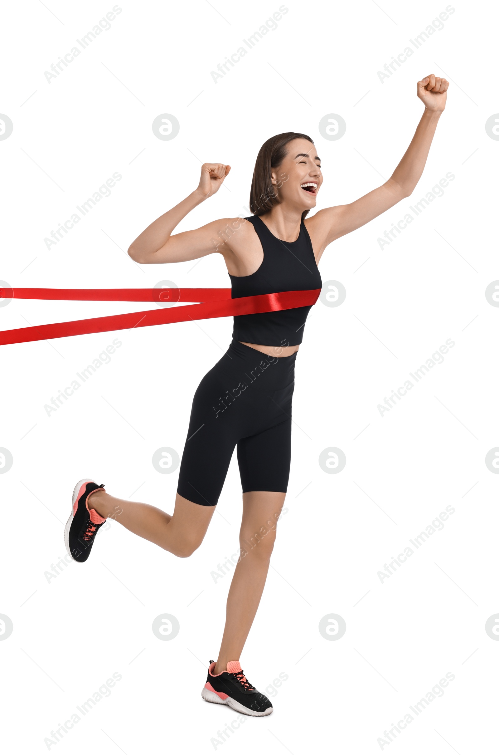 Photo of Beautiful woman in sportswear crossing red finish line on white background