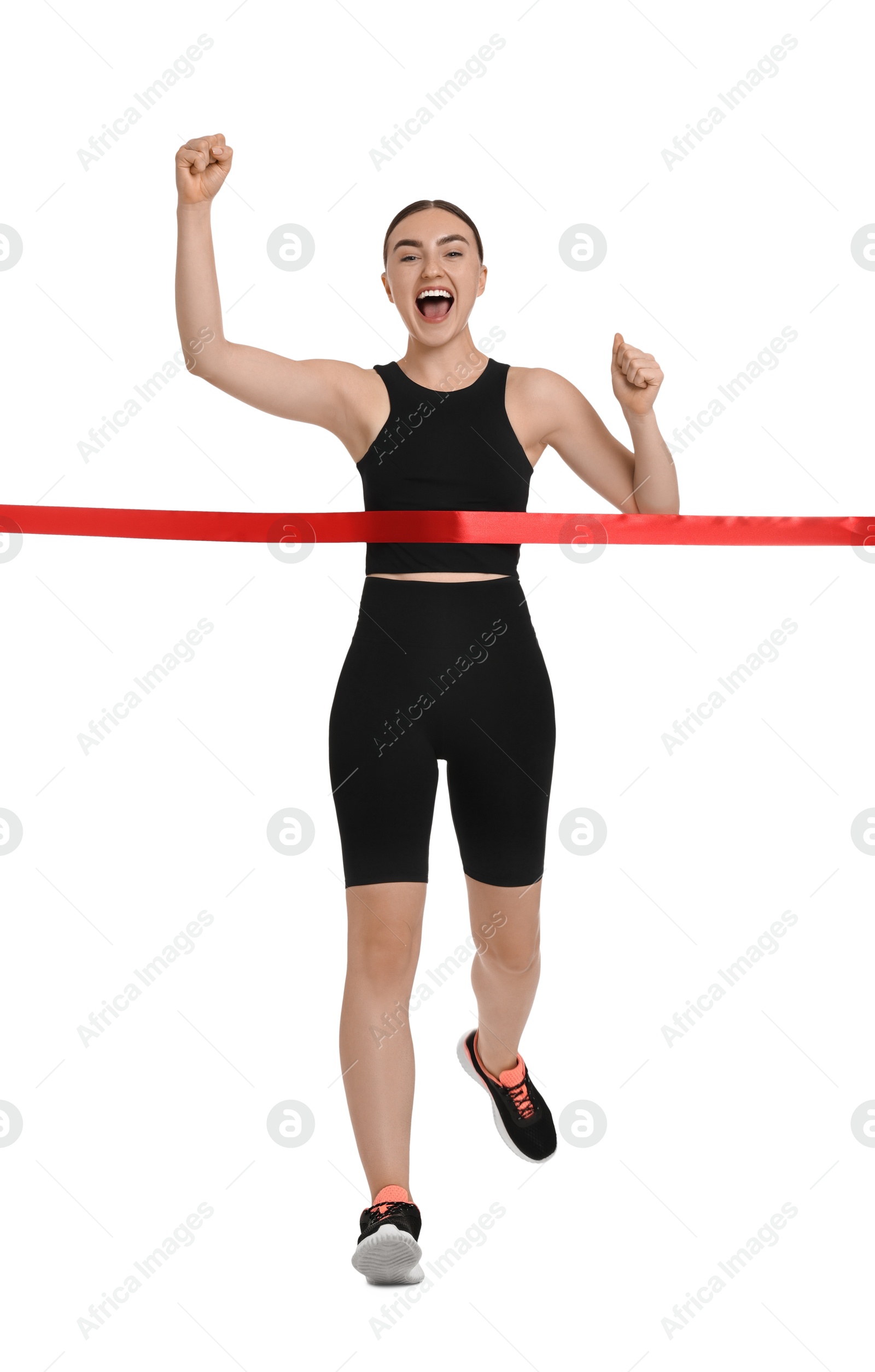 Photo of Beautiful woman in sportswear crossing red finish line on white background