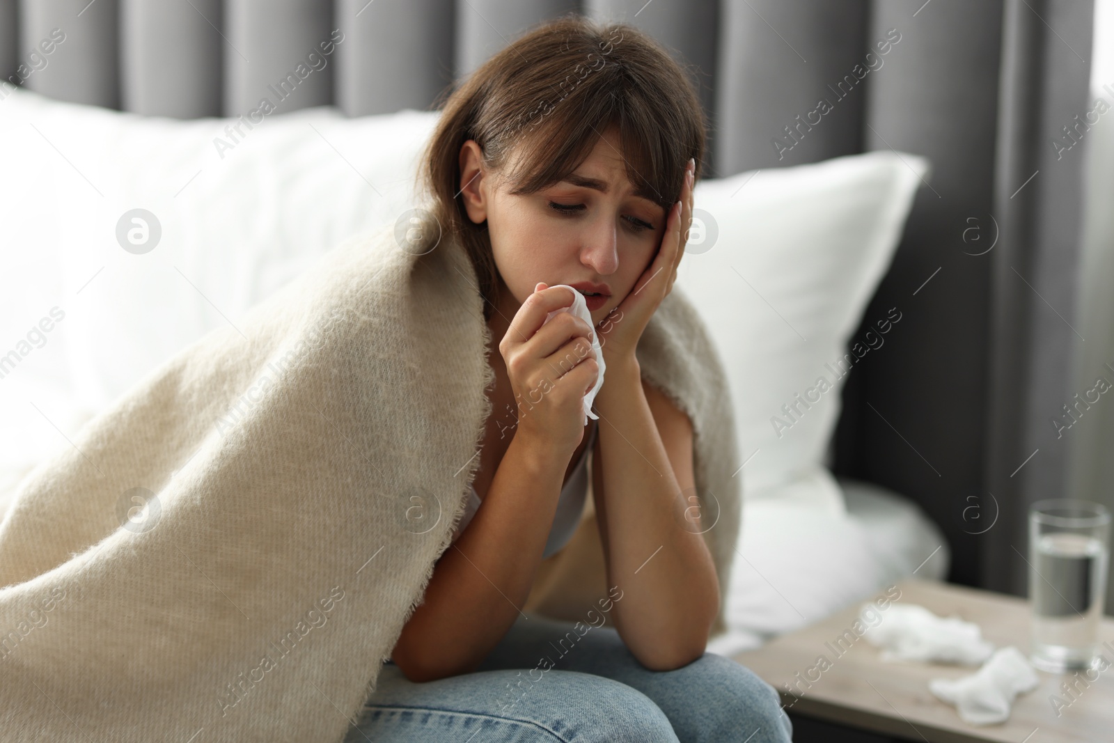 Photo of Woman wrapped in blanket suffering from sinusitis at home