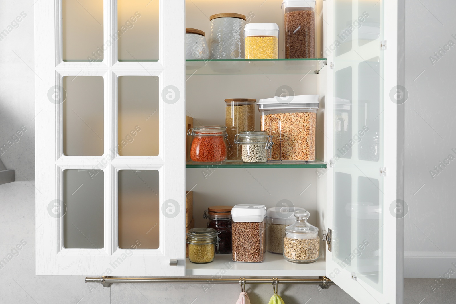 Photo of Different types of cereals and legumes in containers in kitchen