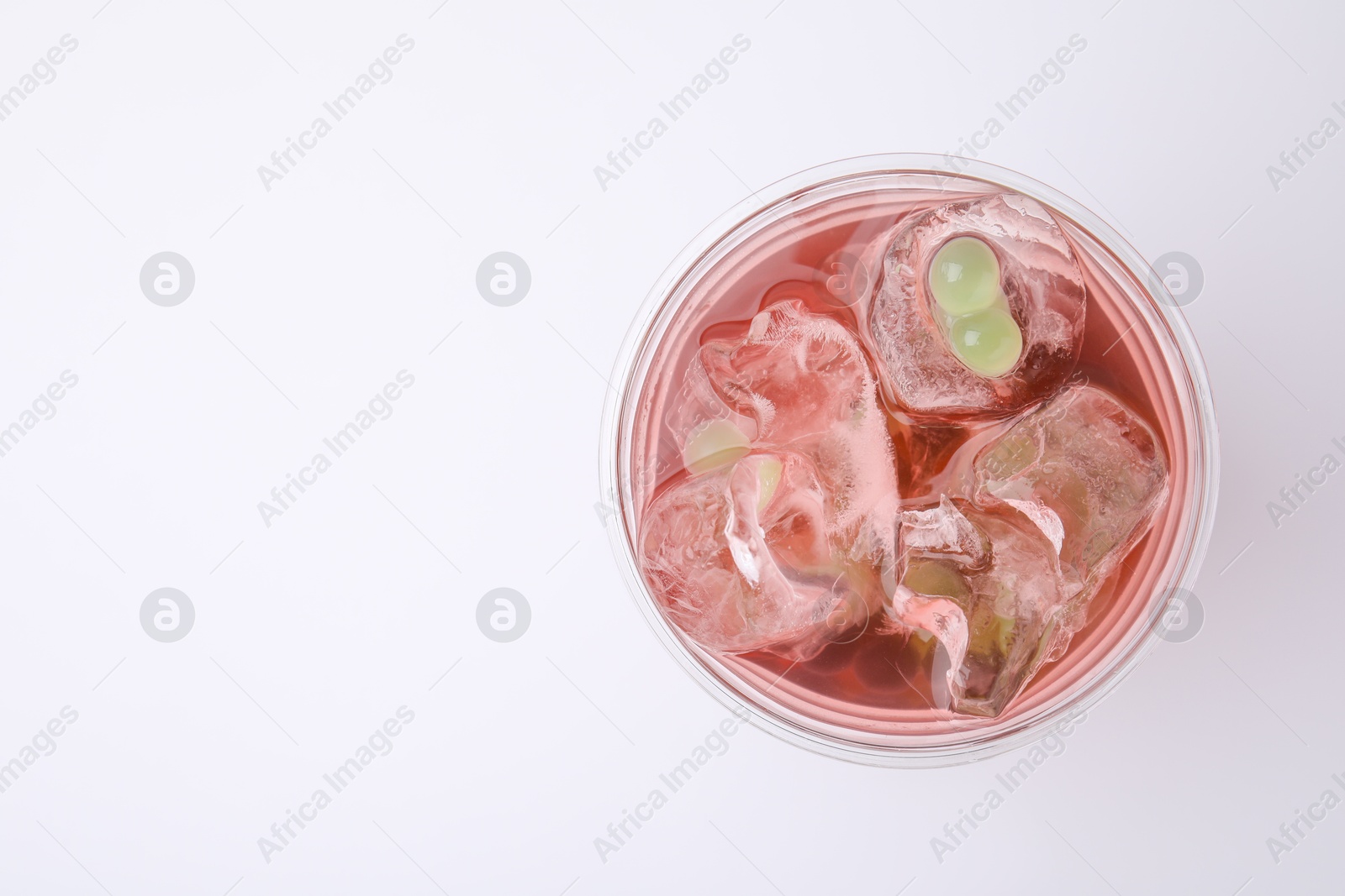 Photo of Tasty bubble tea in plastic cup on white background, top view. Space for text