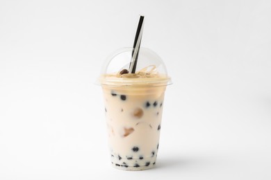 Photo of Tasty milk bubble tea in plastic cup on white background