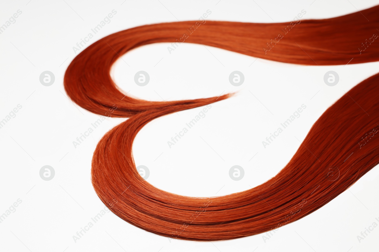 Photo of Red hair strands in shape of heart on white background, closeup