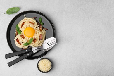 Photo of Delicious pasta Carbonara served on light gray table, flat lay. Space for text