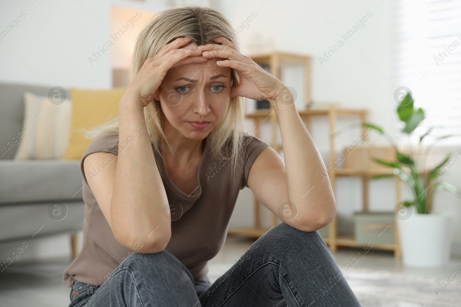 Photo of Menopause. Woman suffering from headache at home