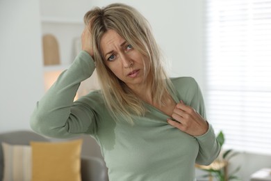 Photo of Menopause. Woman suffering from hot flash at home