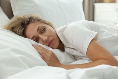 Menopause, sleep problems. Woman suffering from insomnia in bed indoors