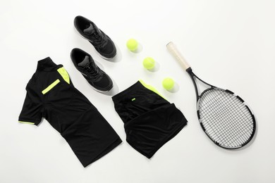 Photo of Tennis racket, balls and sportswear on white background, flat lay