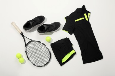 Photo of Tennis racket, balls and sportswear on white background, flat lay