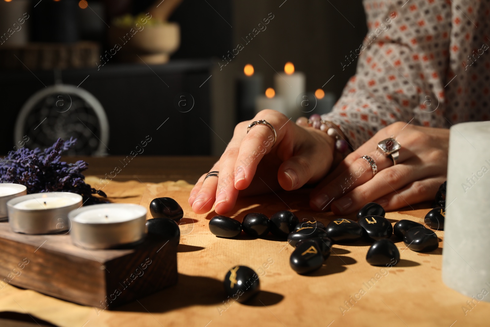 Photo of Woman with black runes at table indoors, closeup