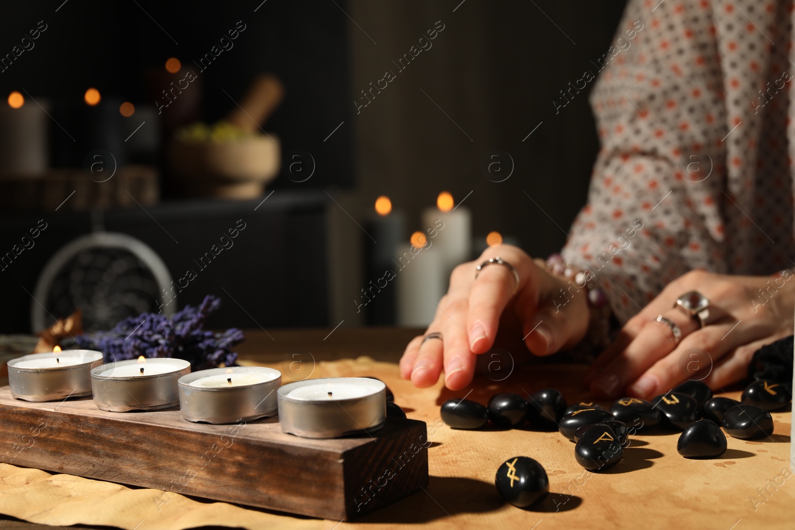 Photo of Woman with black runes at table indoors, closeup