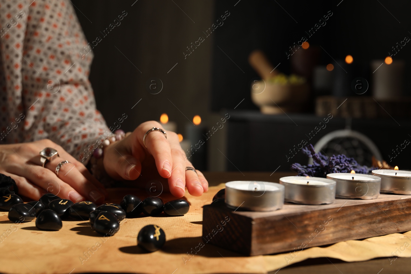 Photo of Woman with black runes at table indoors, closeup