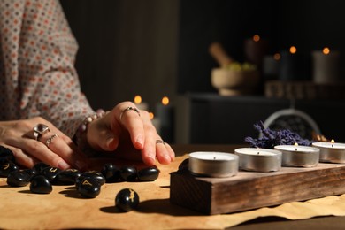 Photo of Woman with black runes at table indoors, closeup