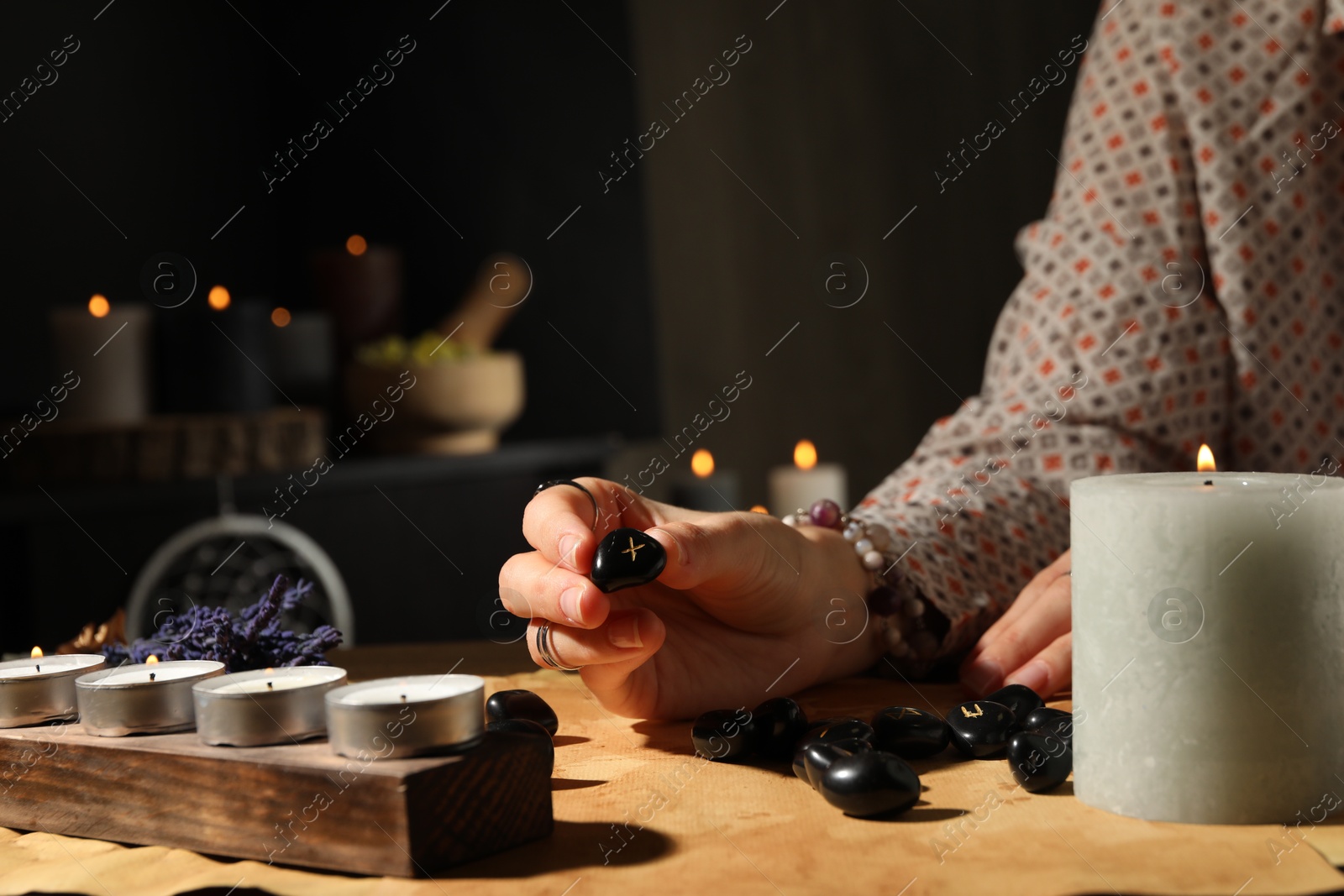 Photo of Woman with rune Gebo at table indoors, closeup