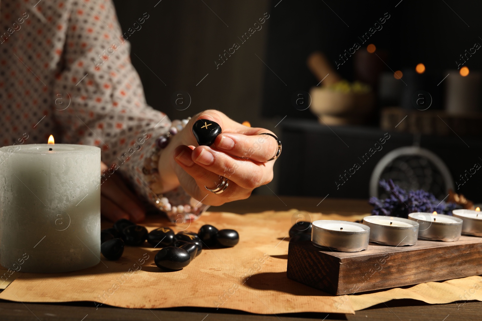 Photo of Woman with rune Gebo at table indoors, closeup