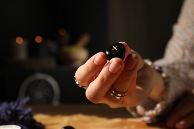 Photo of Woman with rune Gebo at table indoors, closeup