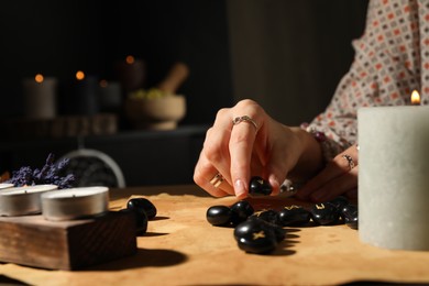 Photo of Woman with black runes at table indoors, closeup