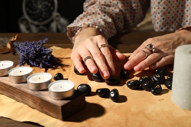 Photo of Woman with black runes at table indoors, closeup