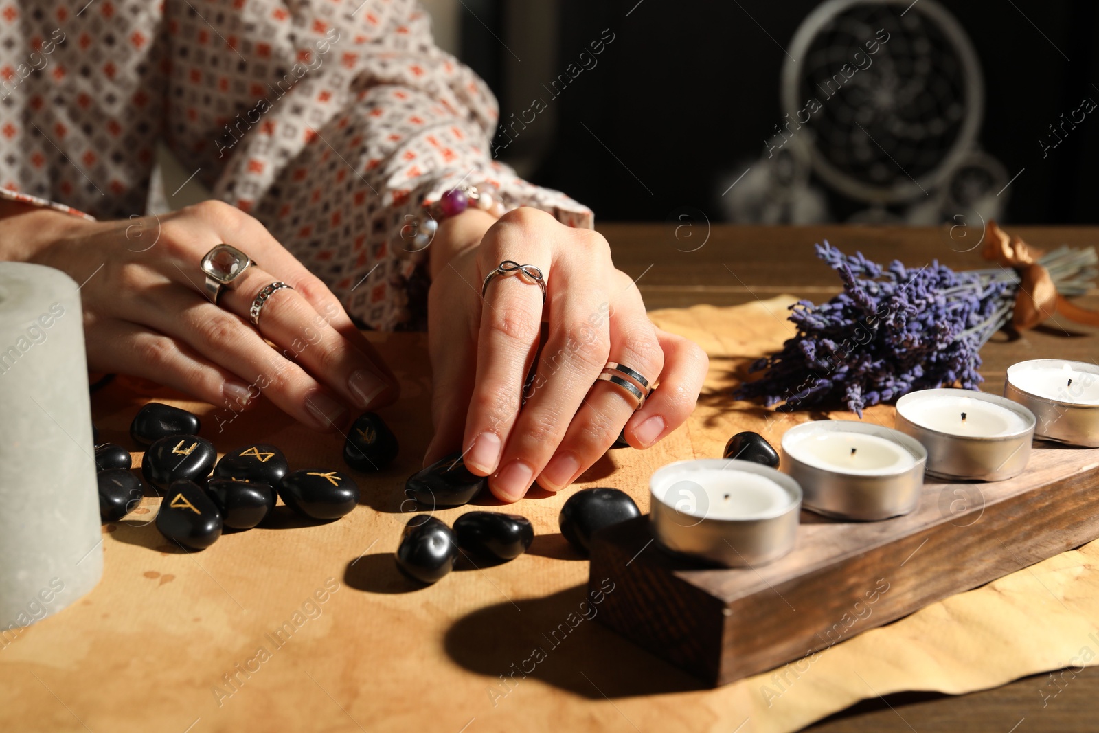 Photo of Woman with black runes at table indoors, closeup