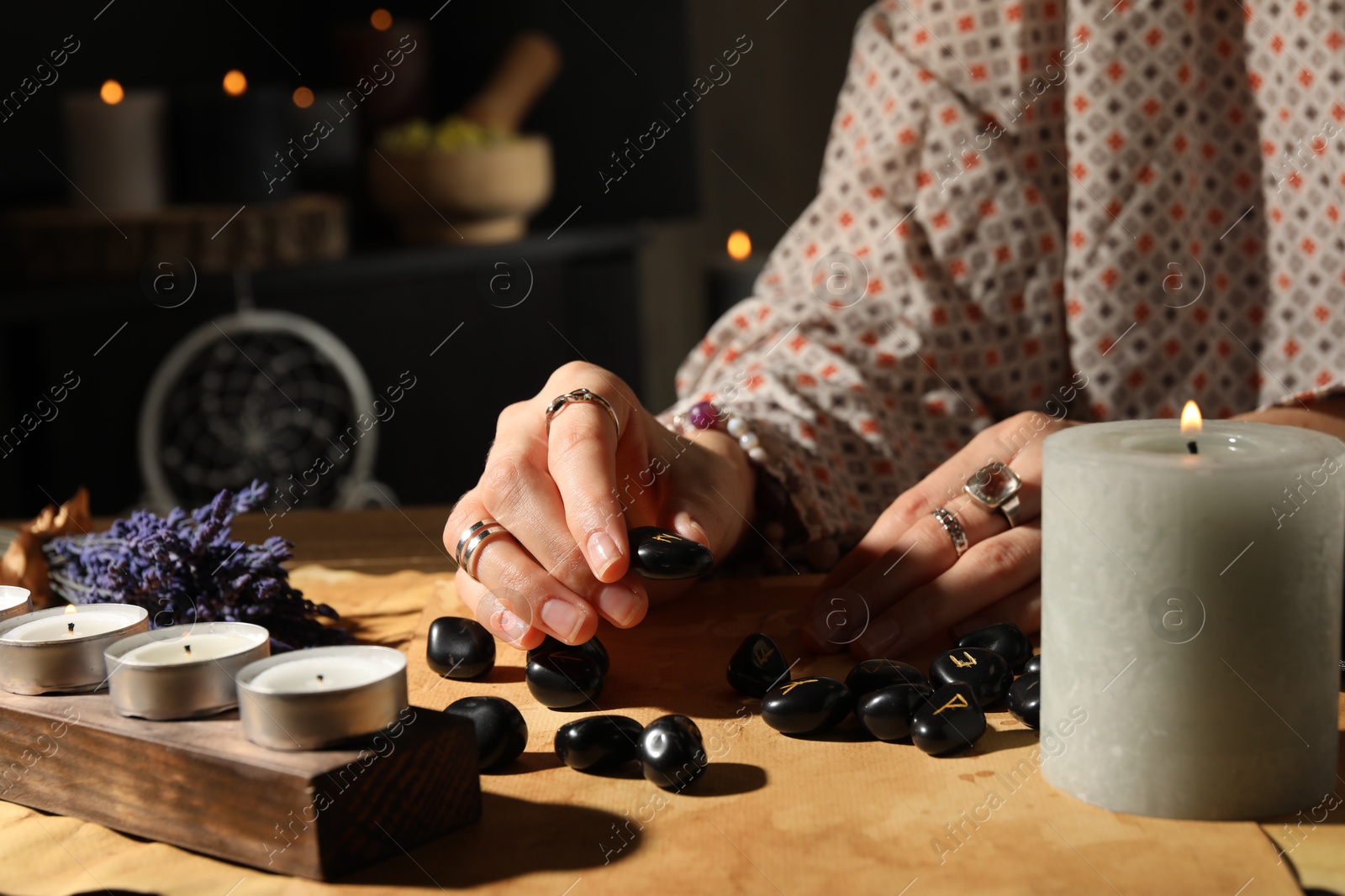 Photo of Woman with black runes at table indoors, closeup