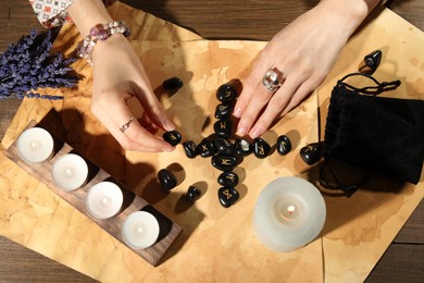 Photo of Woman with black runes at table, top view