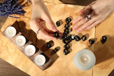 Photo of Woman with black runes at table, top view