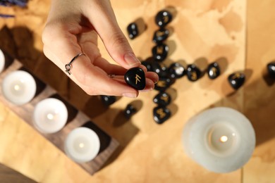 Photo of Woman with black runes at table, top view