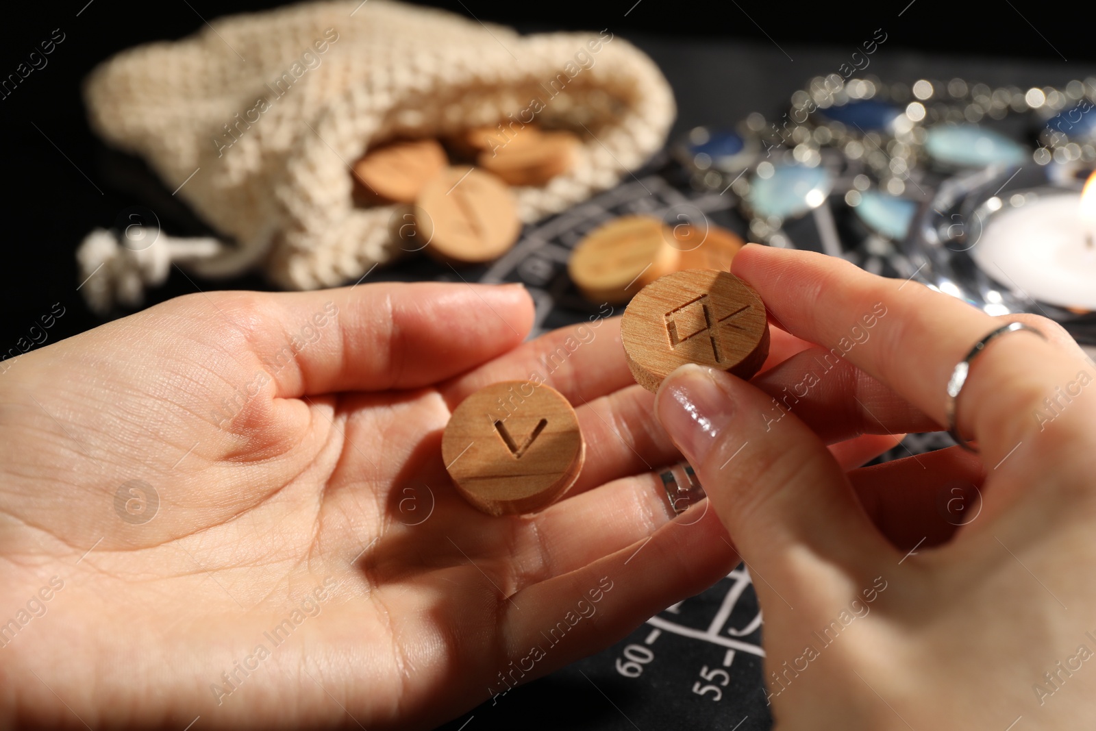 Photo of Woman with wooden runes at table, closeup