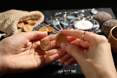 Photo of Woman with wooden runes at divination mat, closeup