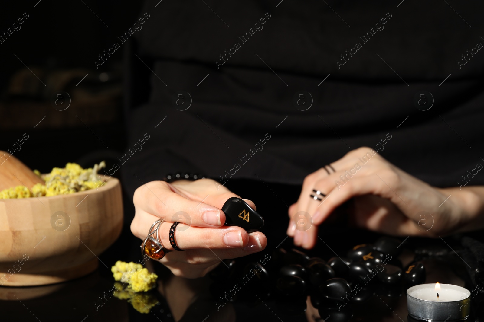 Photo of Woman with black runes at table, closeup