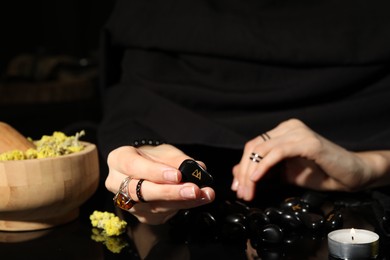 Photo of Woman with black runes at table, closeup