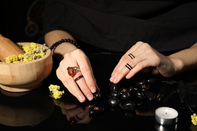 Woman with black runes at table, closeup