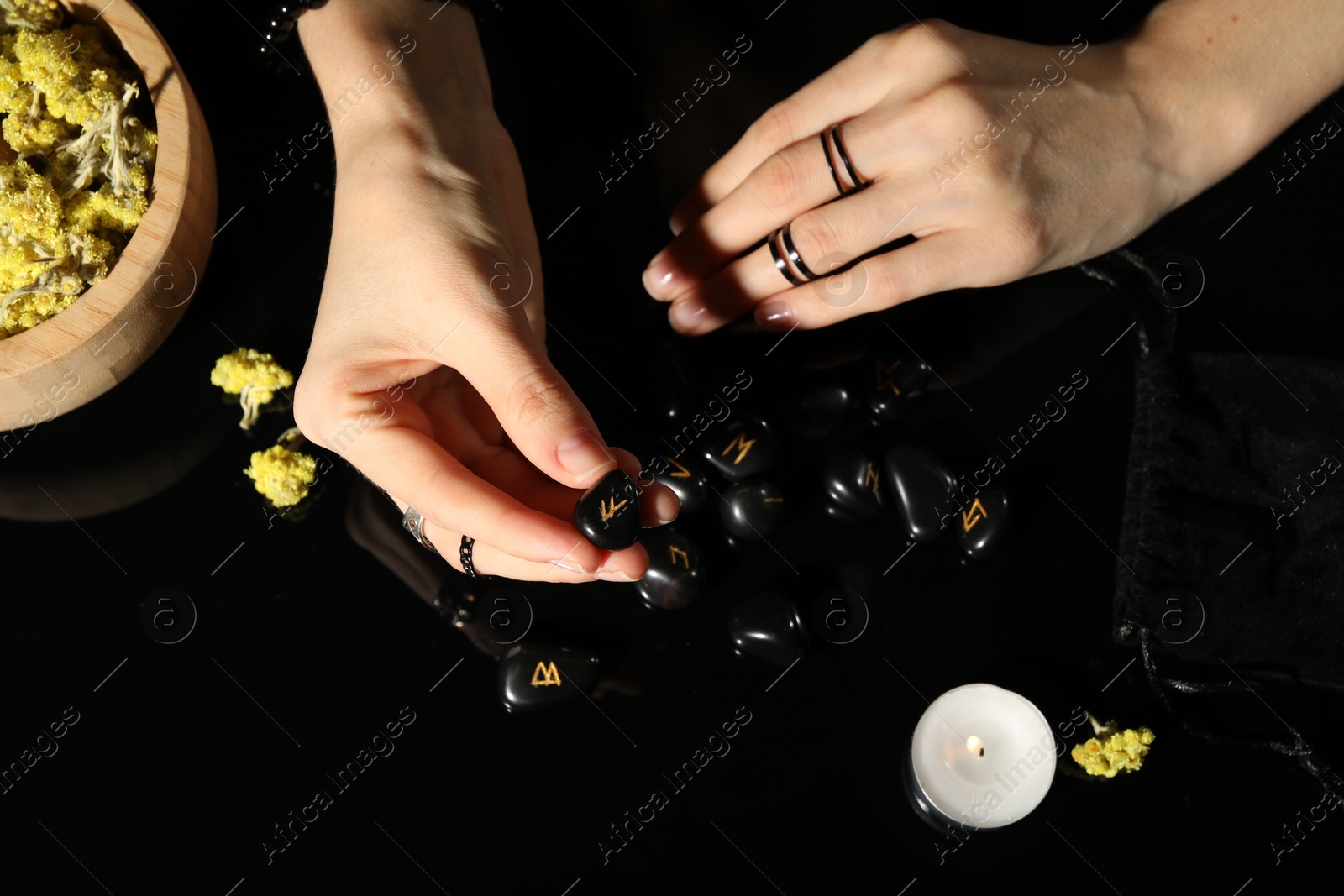 Photo of Woman with black runes at table, top view