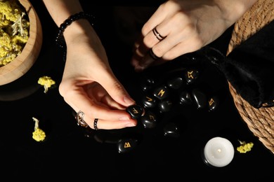 Photo of Woman with black runes at table, top view