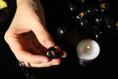 Photo of Woman with black rune Ansuz at table, top view