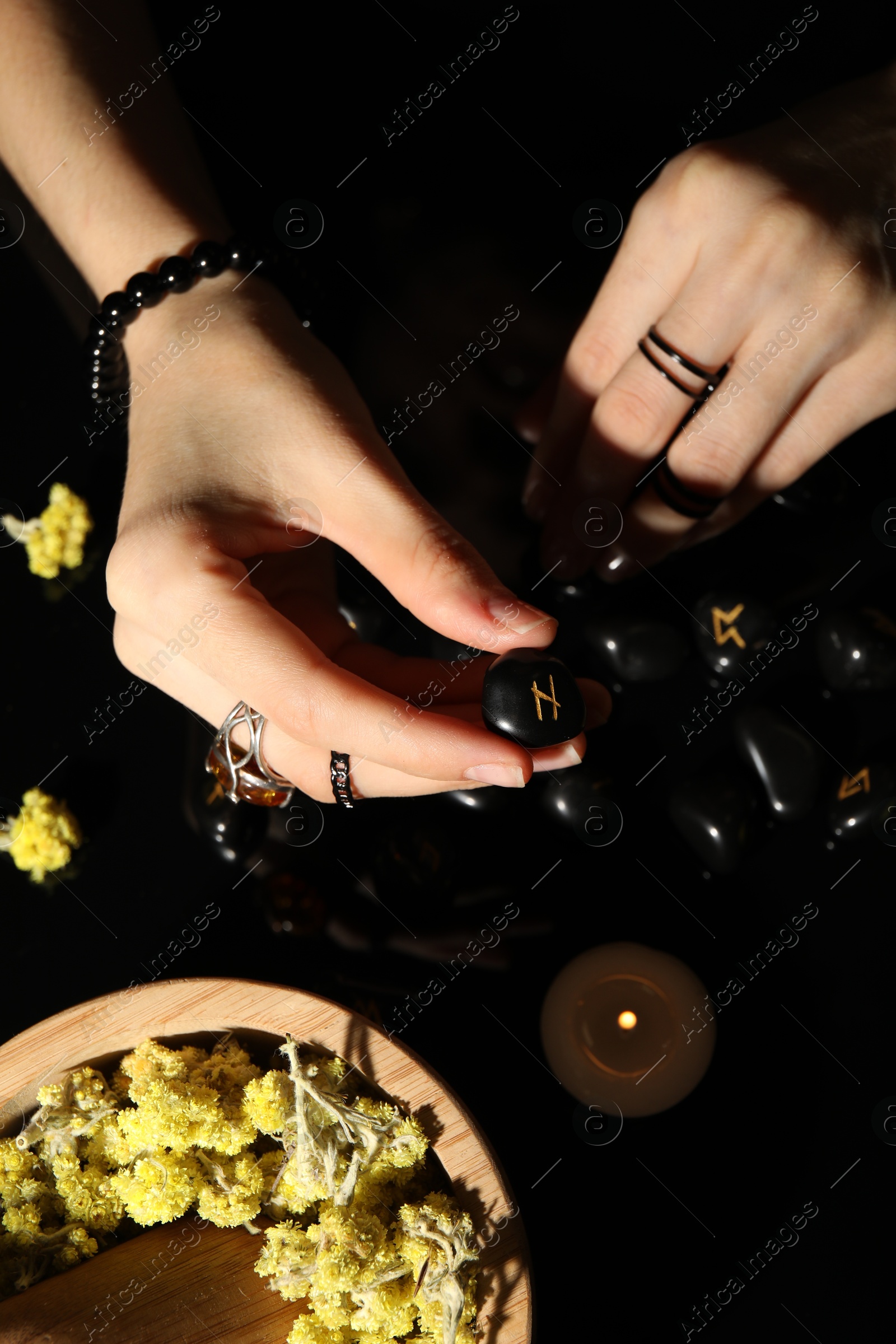 Photo of Woman with black rune Hagalaz at table, top view