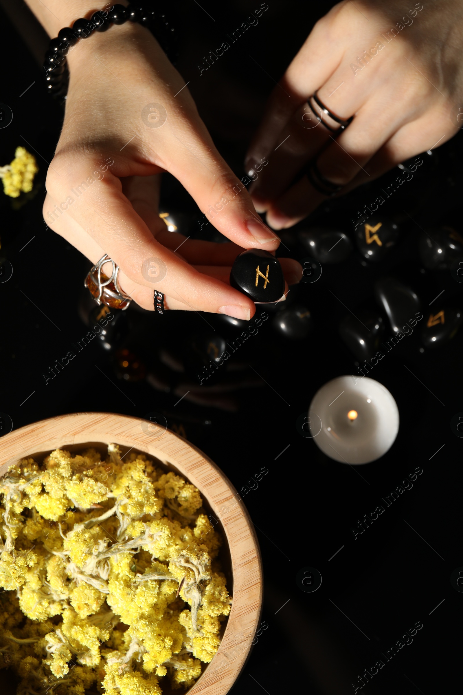 Photo of Woman with black rune Hagalaz at table, top view