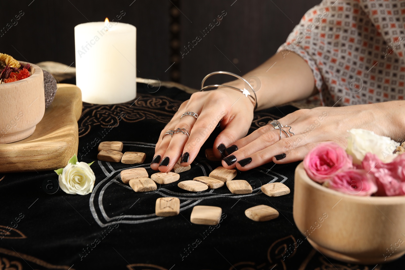 Photo of Woman with wooden runes at divination mat, closeup