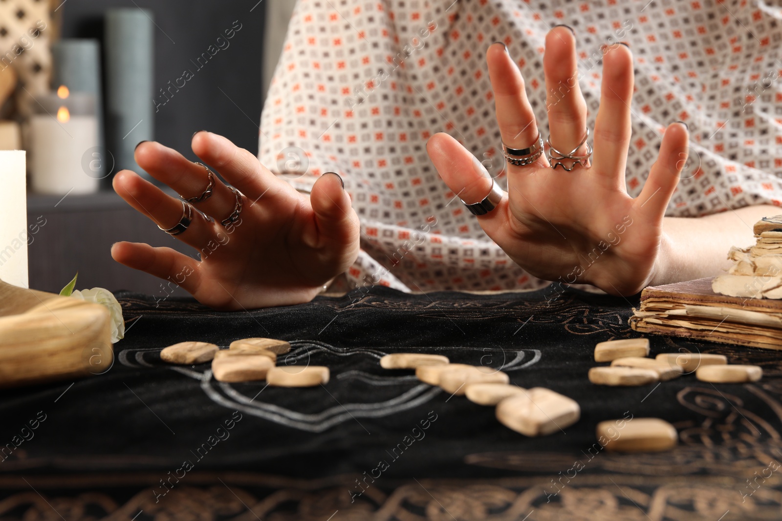 Photo of Woman with wooden runes at divination mat, closeup