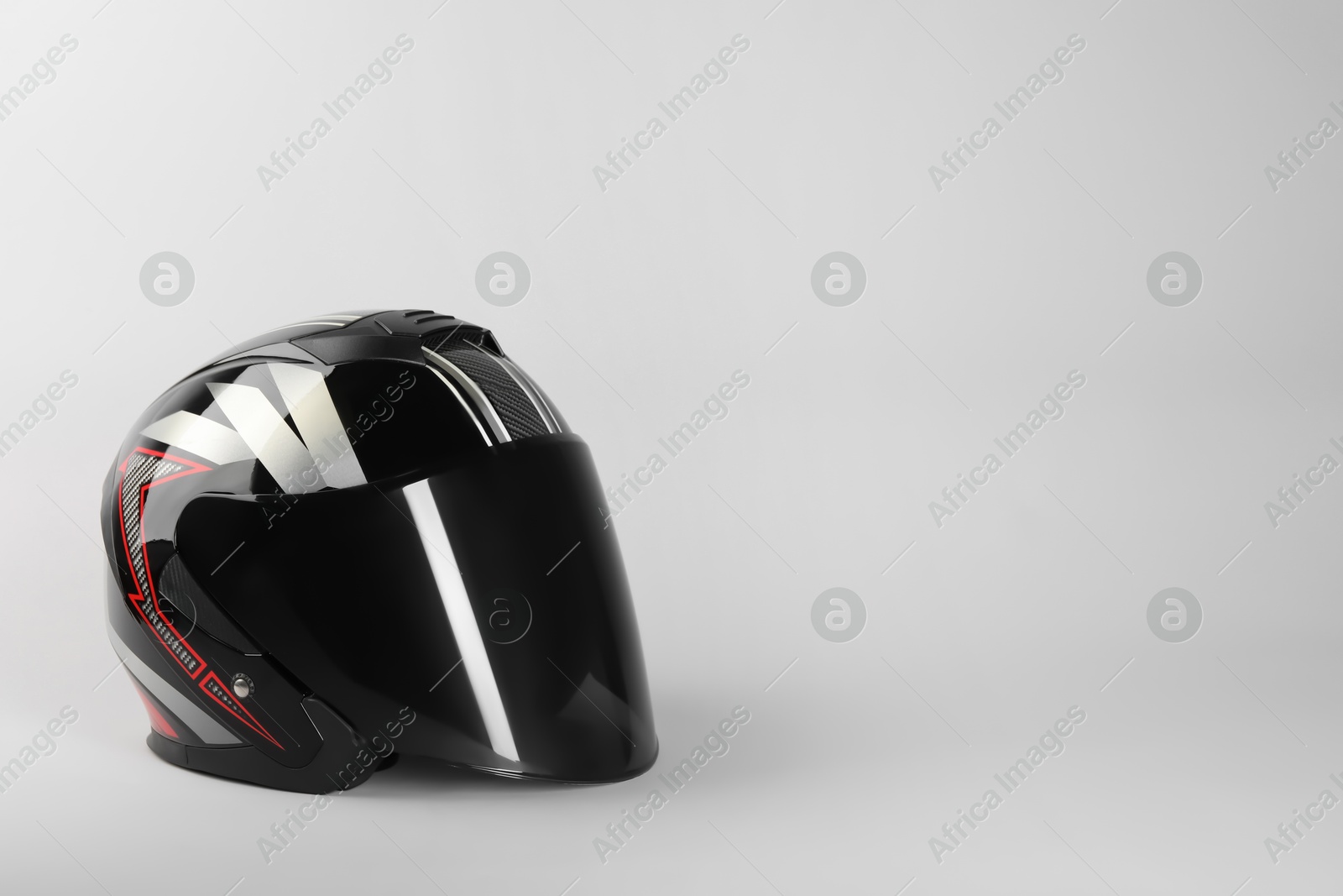 Photo of Motorcycle helmet with visor on light grey background, space for text