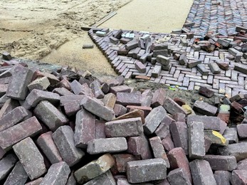 Photo of Process of laying paving stone blocks outdoors