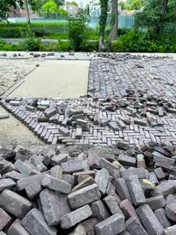 Photo of Process of laying paving stone blocks outdoors