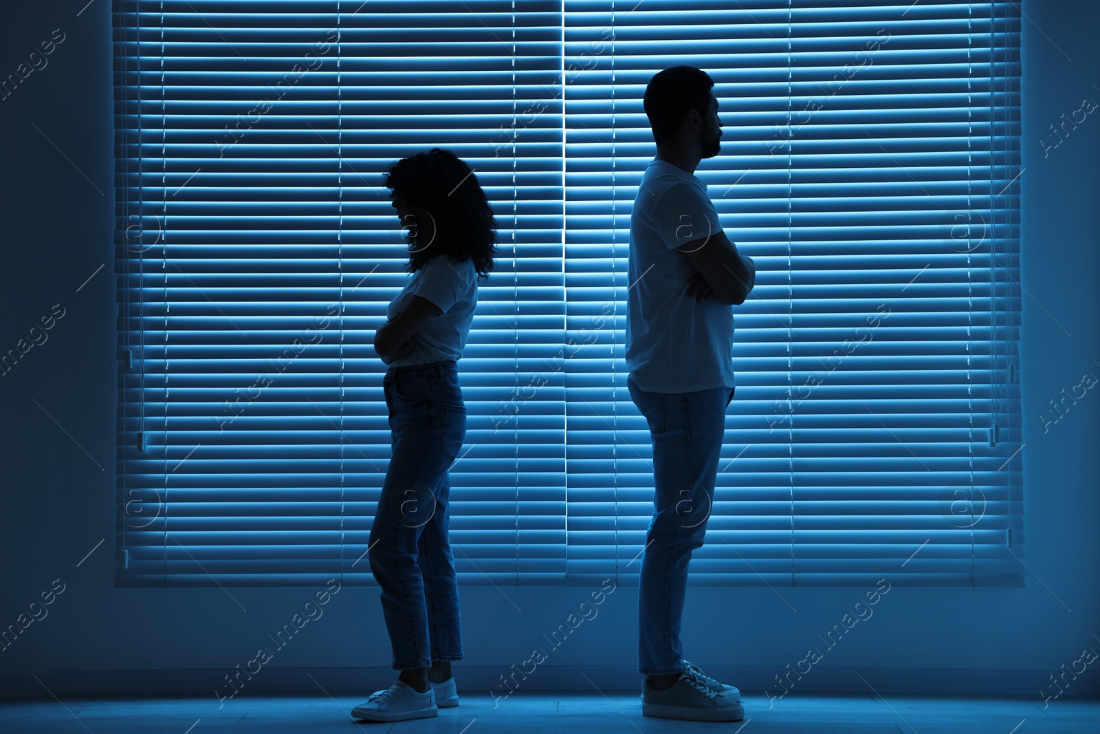 Photo of Couple having quarrel indoors at night. Relationship problems