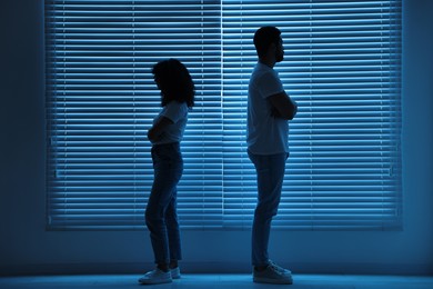 Photo of Couple having quarrel indoors at night. Relationship problems